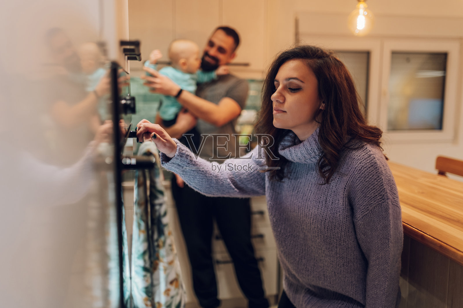 年轻的一家人在家里一起烤蛋糕照片摄影图片