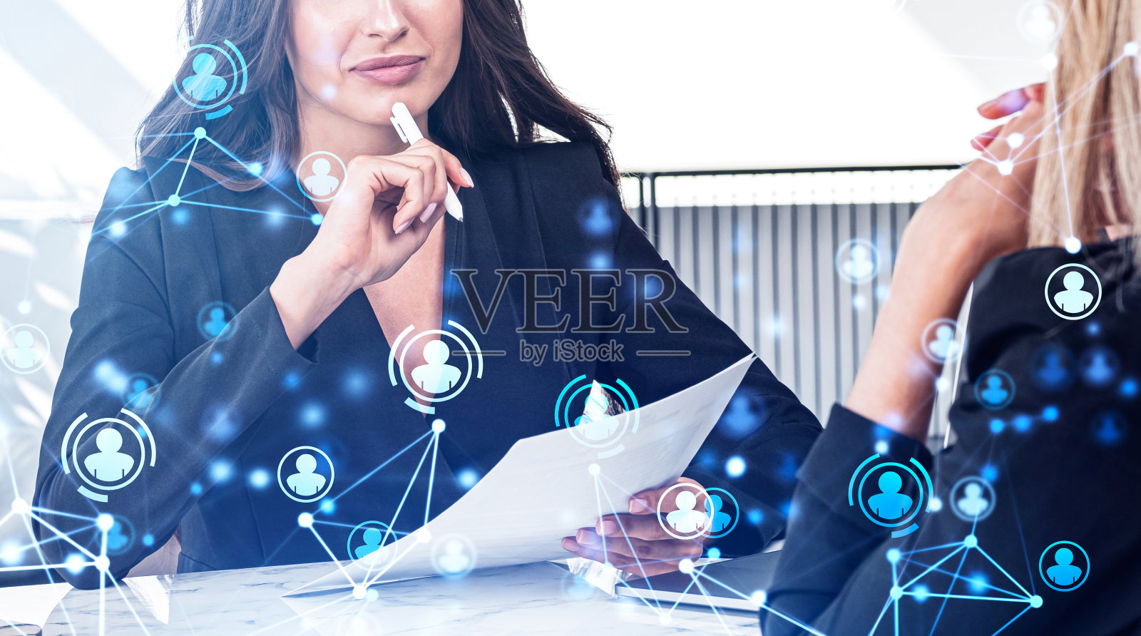 年轻迷人的女商人，穿着正装正在与同事交谈照片摄影图片