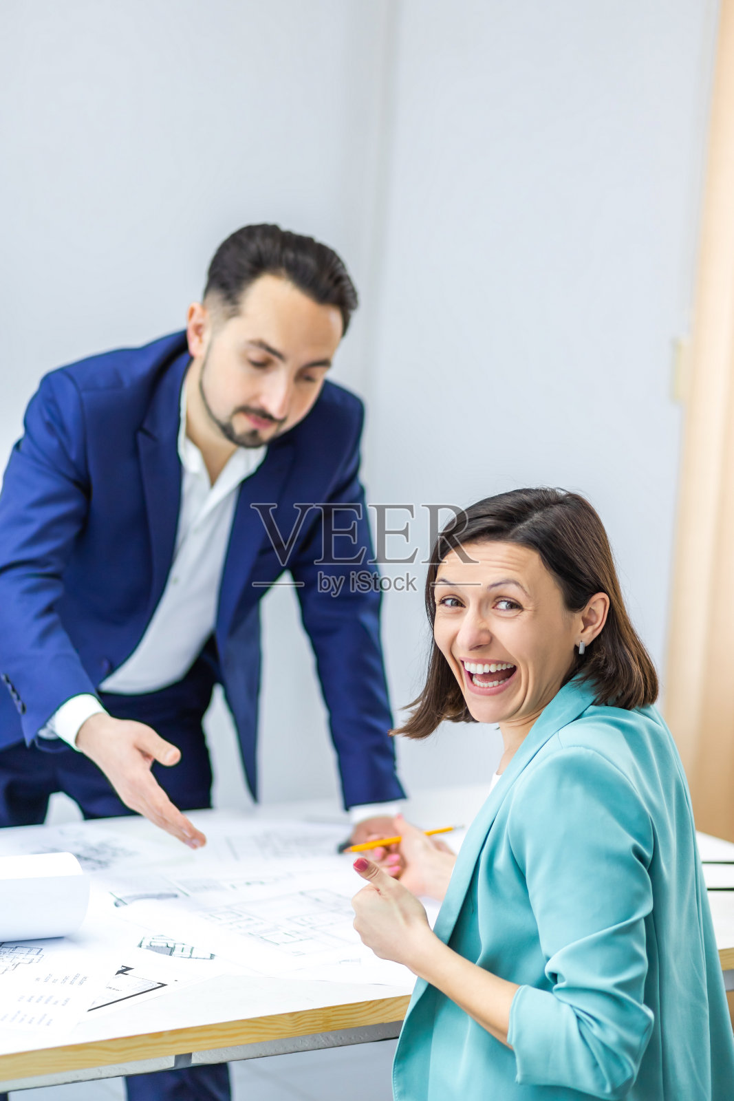 在现代的办公室里，同事们穿着正装聚在一起讨论商业点子。照片摄影图片