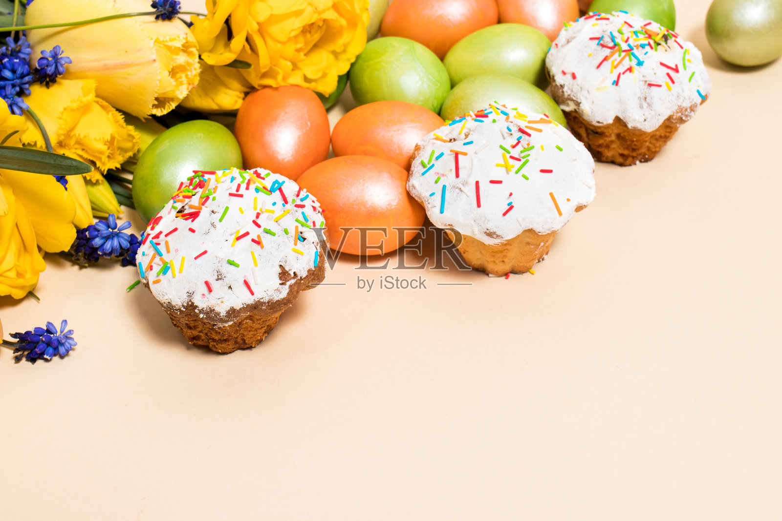 复活节蛋糕，鸡蛋和黄色郁金香在米色背景与文本空间。照片摄影图片