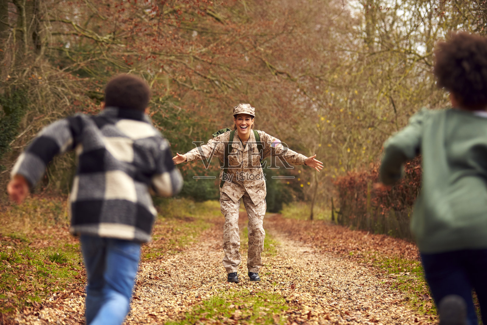 美国女兵休假回家，受到两个孩子的欢迎照片摄影图片
