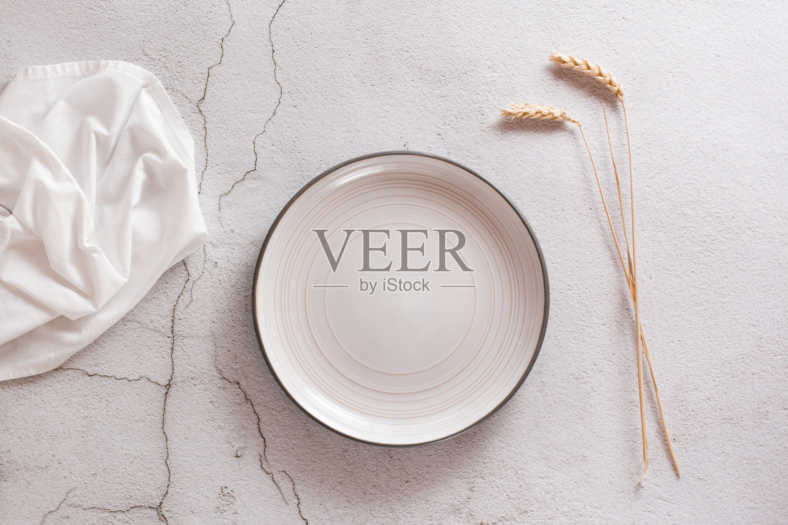 生态模拟。一个空的板，布和耳朵在一个浅色的混凝土背景。前视图。照片摄影图片