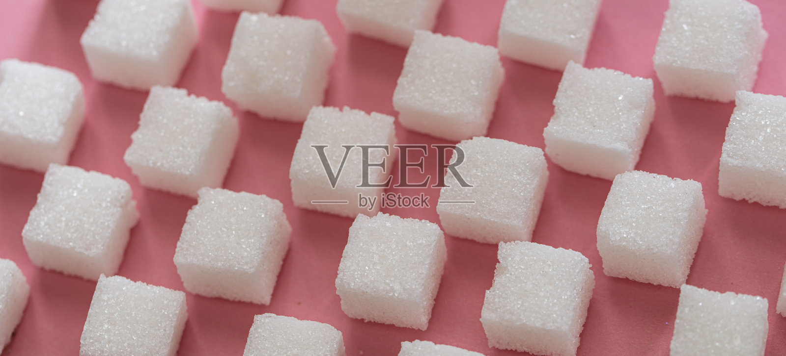 粉红色背景上的方糖照片摄影图片