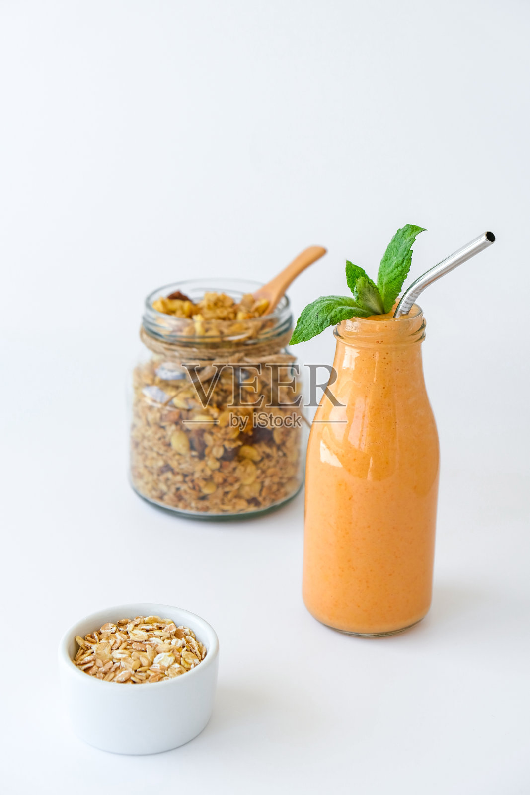 季节性南瓜胡萝卜冰沙饮料排毒与生态金属饮用吸管玻璃罐格兰诺拉燕麦什锦早餐。橙色的奶昔。清洁饮食、减肥、健康饮食的食品理念照片摄影图片