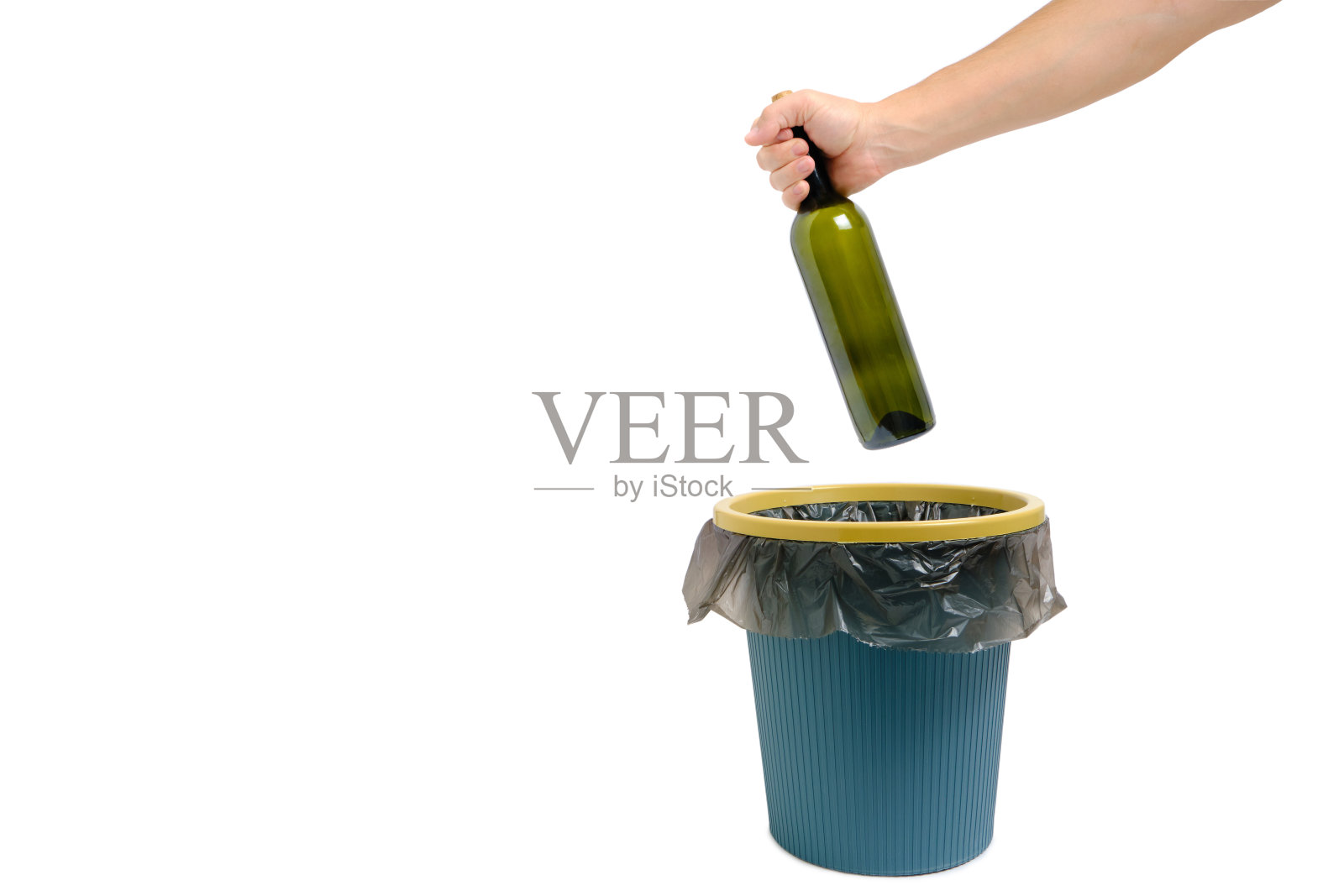手里拿着一个空酒瓶扔进了垃圾桶。照片摄影图片