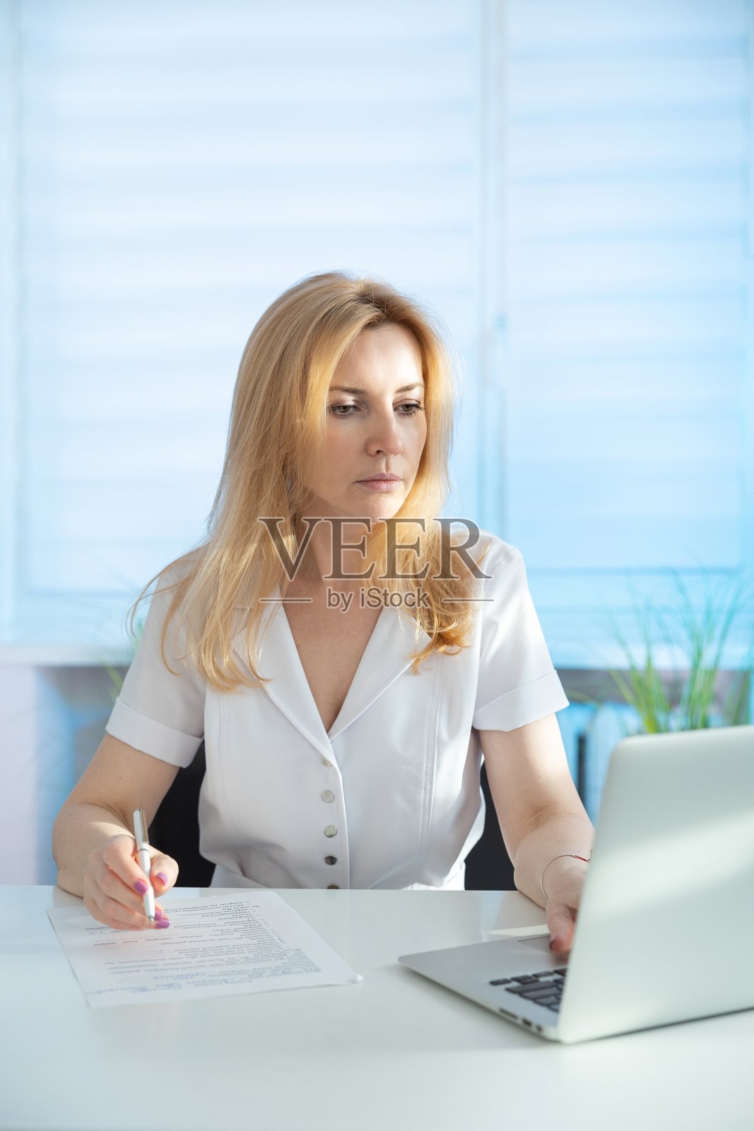 一个女美容师的肖像在她的办公桌上。照片摄影图片