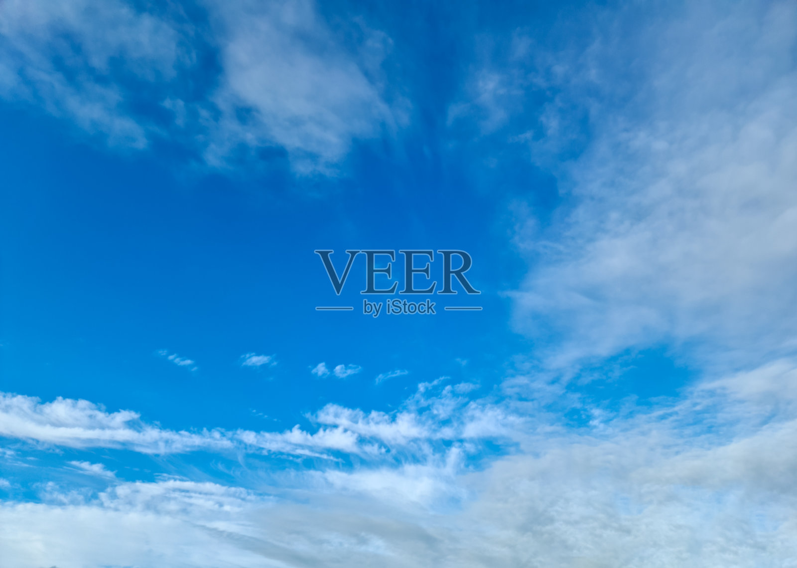 在湛蓝的夏日天空中，美丽的蓬松的白云形成照片摄影图片