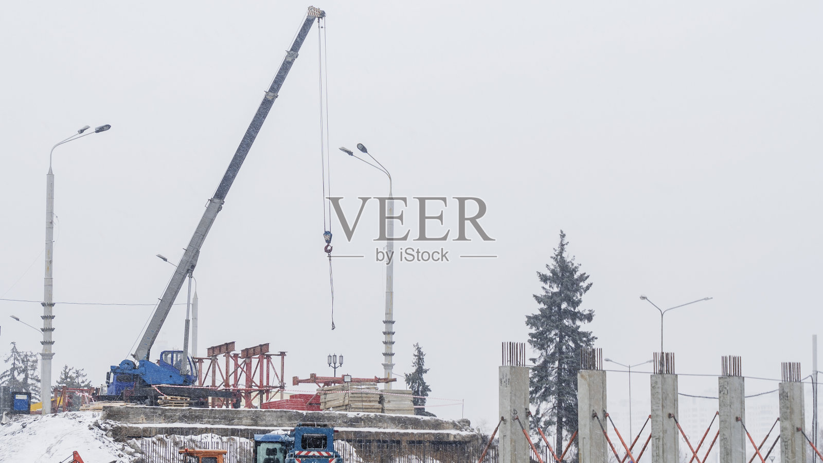 雪天建筑工地的景象。冬天在城市里建造一座新桥。照片摄影图片