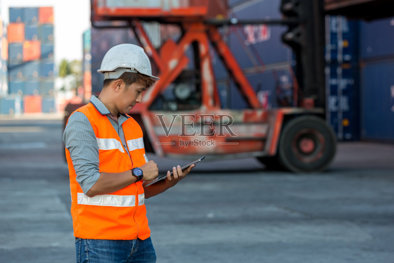 专业的领班在集装箱货场工作，检查集装箱内的货物。工人们正在打开集装箱接受检查。照片摄影图片
