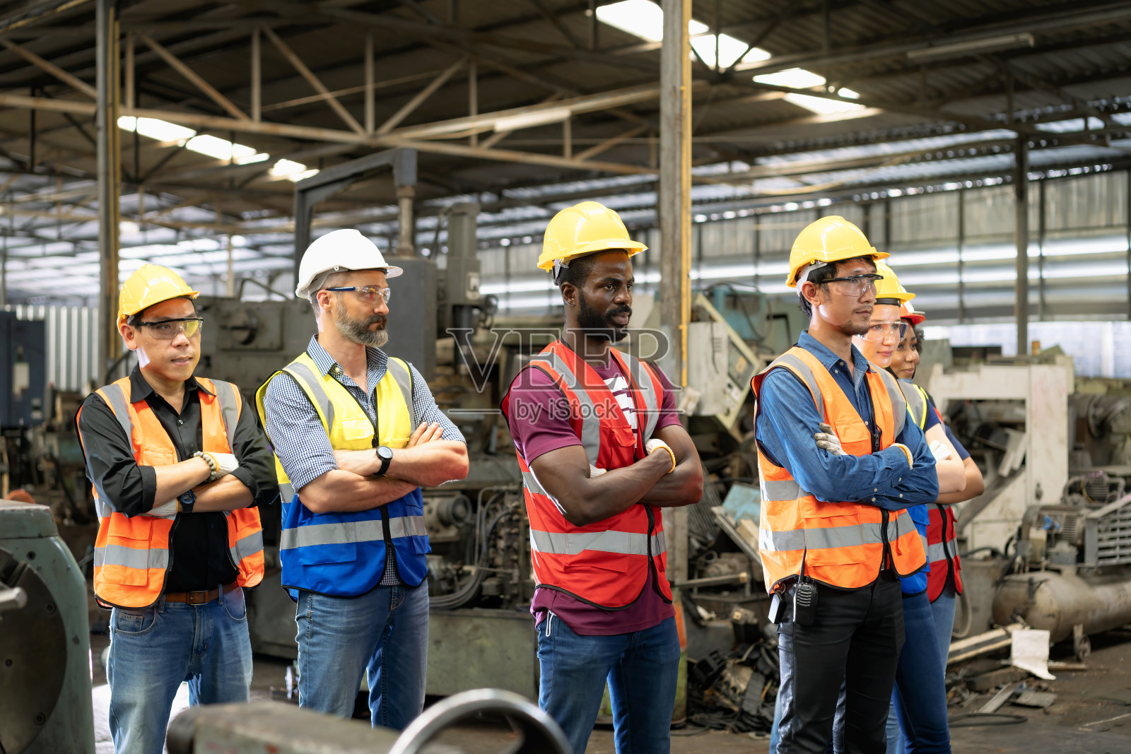 工人们站在工厂里。集团员工站在工程工厂。照片摄影图片