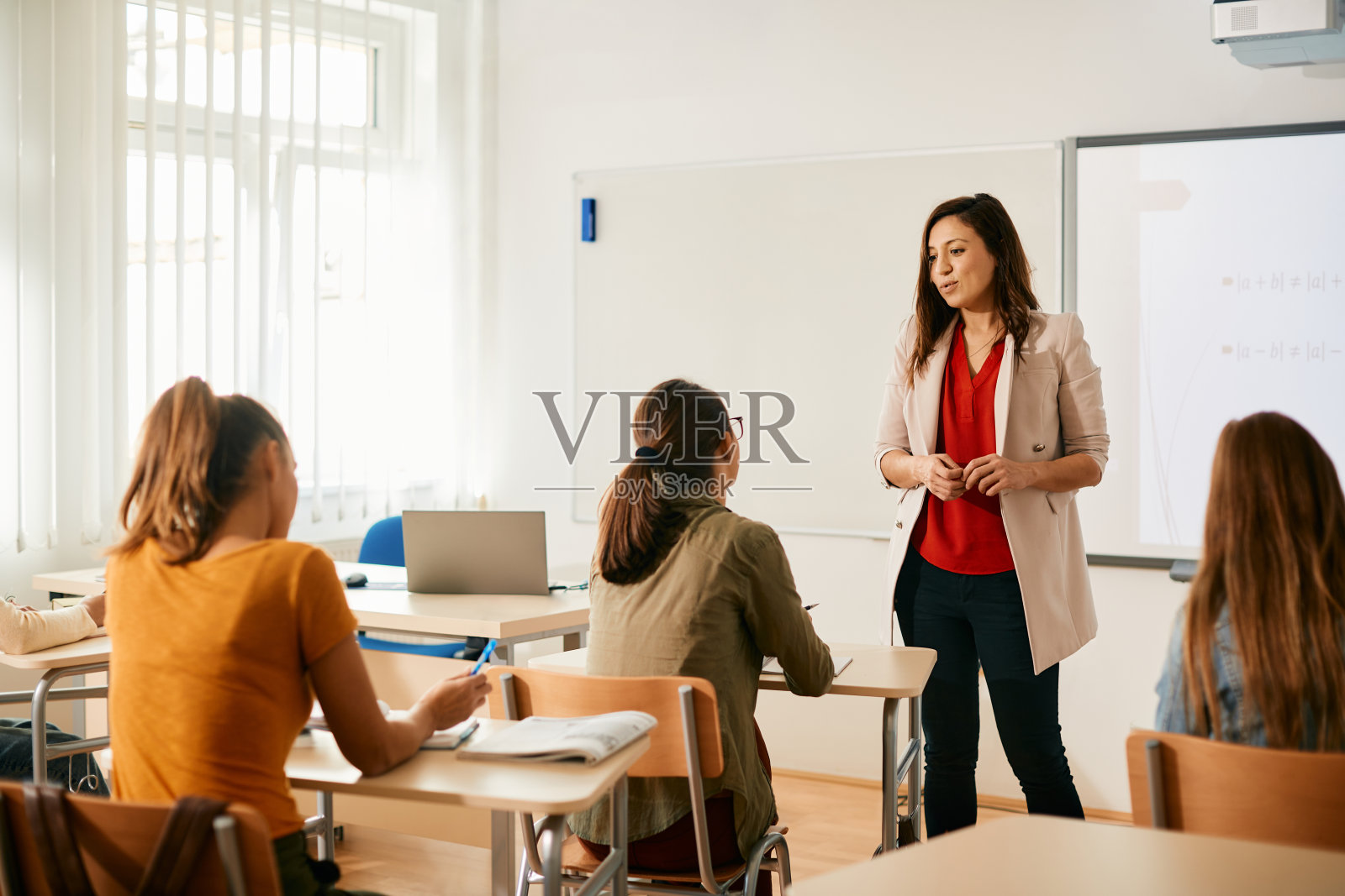 高中老师在教室里给学生讲课。照片摄影图片