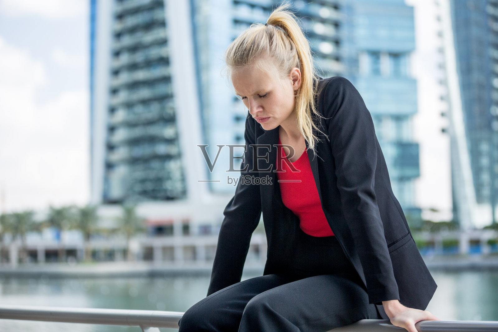 疲惫的年轻女商人独自坐在城市里照片摄影图片