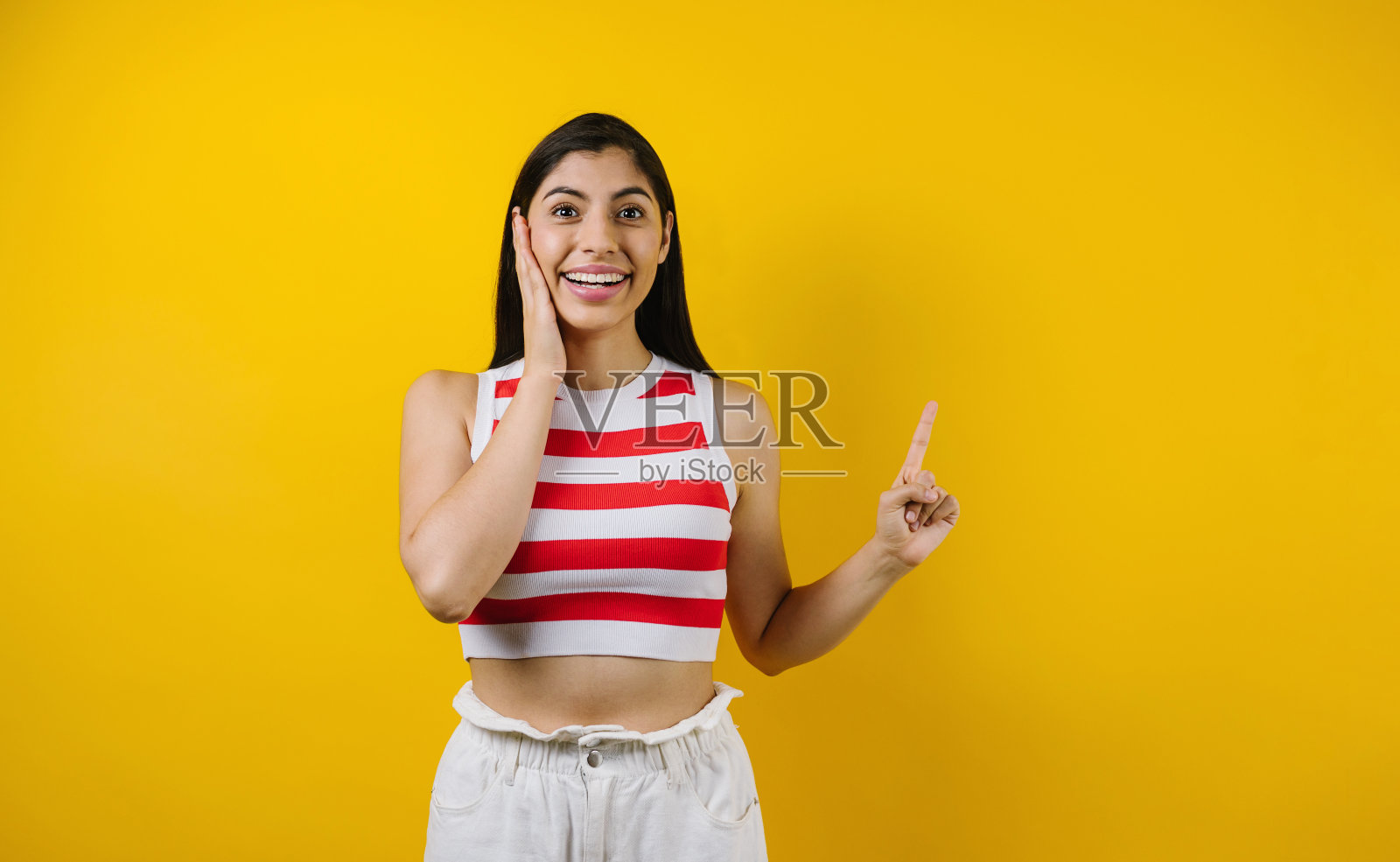 在拉丁美洲的黄色背景上复制空间的黑发年轻拉丁女人的肖像照片摄影图片