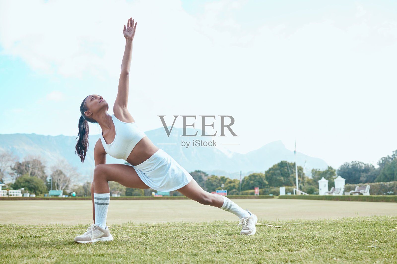 一名年轻女子在打网球时伸展身体的照片照片摄影图片