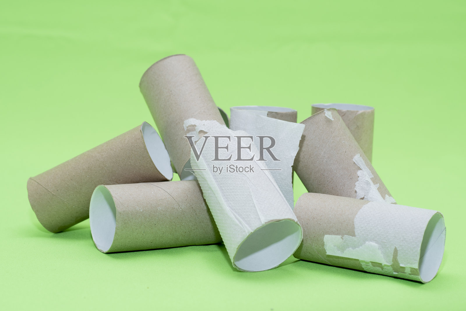 一堆空厕纸管在绿色的背景上。以生态和材料回收为主题的背景。照片摄影图片