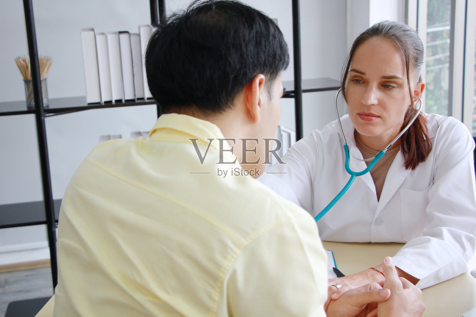 白人女精神科医生为患有精神健康问题的亚洲男性提供咨询和鼓励照片摄影图片