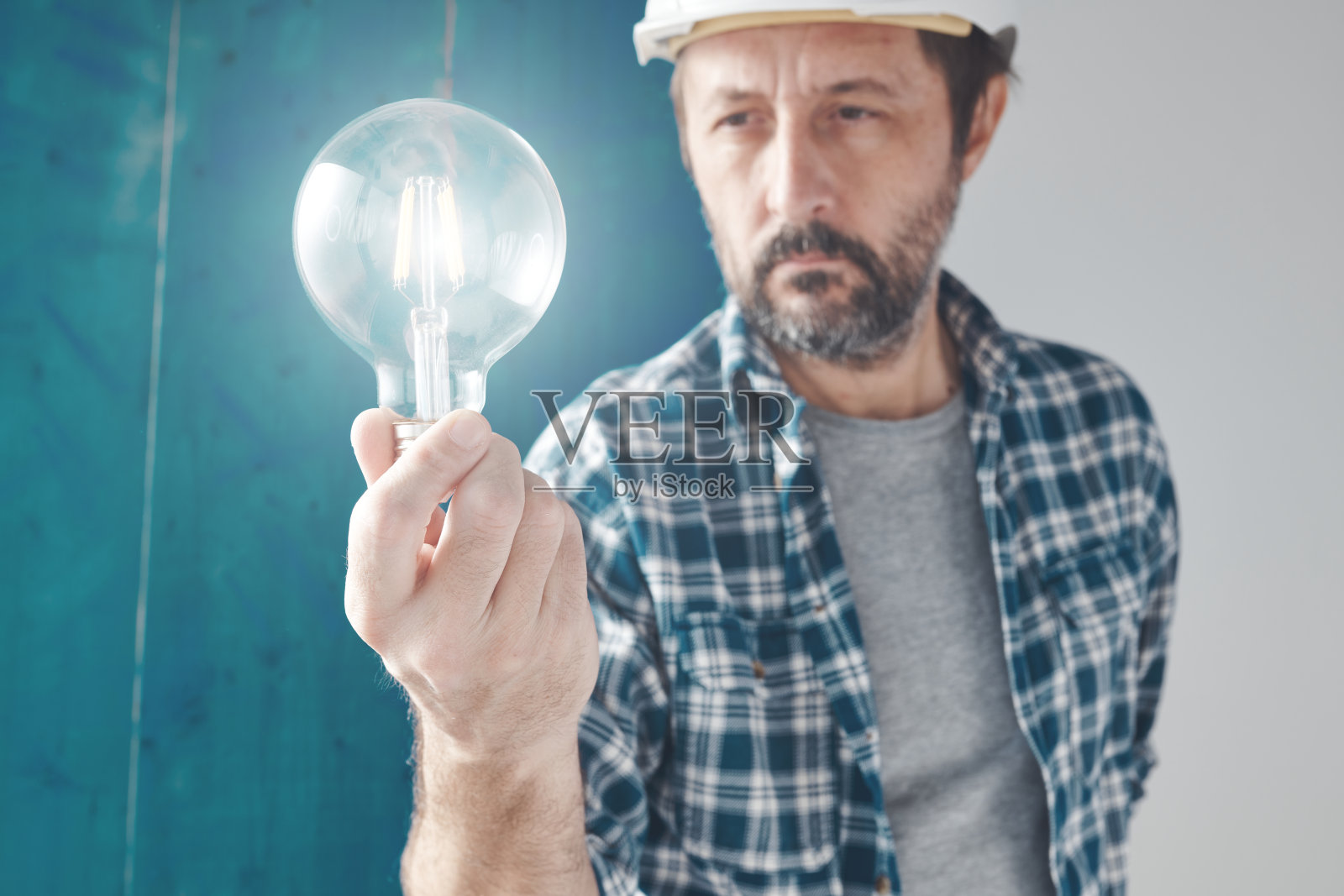 建筑工程师拿着灯泡作为创意和新想法的象征照片摄影图片