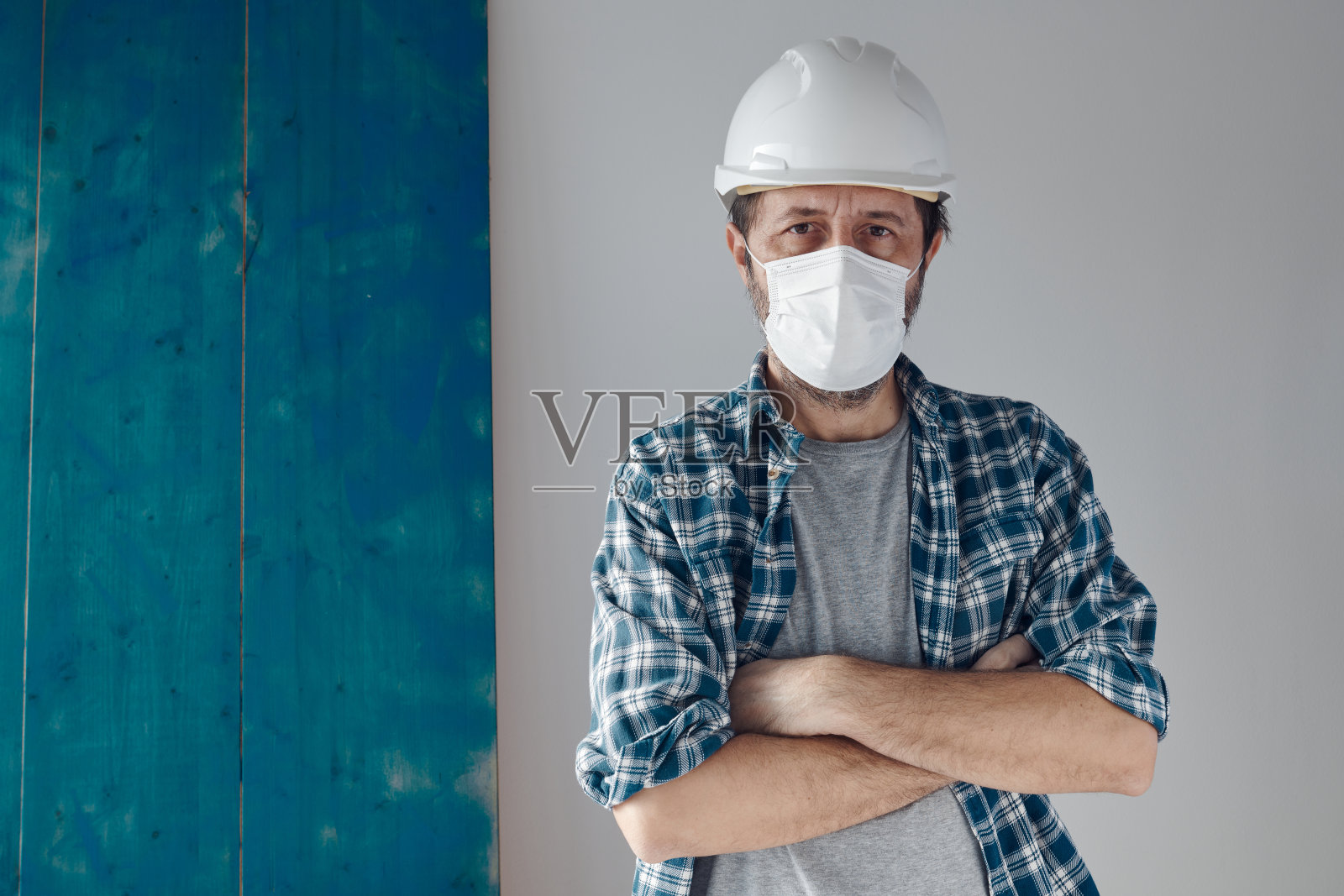 带着防护面罩和白色安全帽的建筑工程师的肖像照片摄影图片