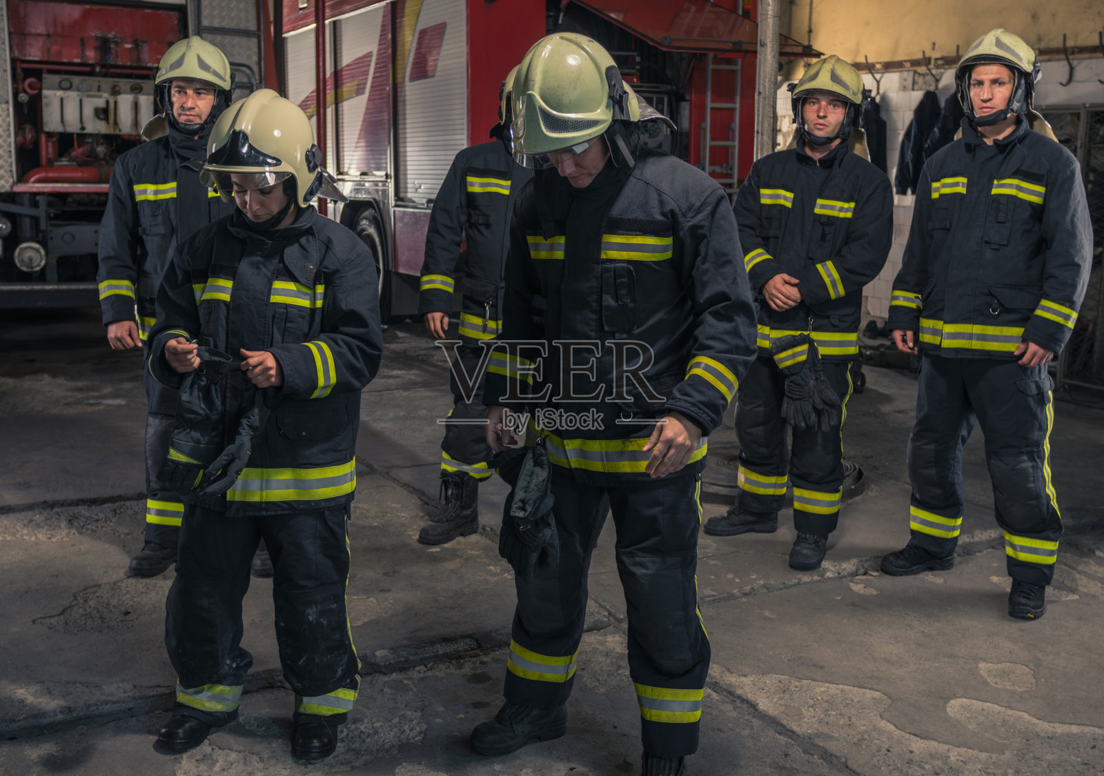 一群双臂交叉的消防员自信地站着。消防队员已准备好应急服务。照片摄影图片