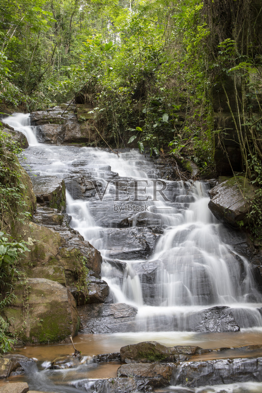 瀑布与白雾形成，在岩石和植被之间照片摄影图片