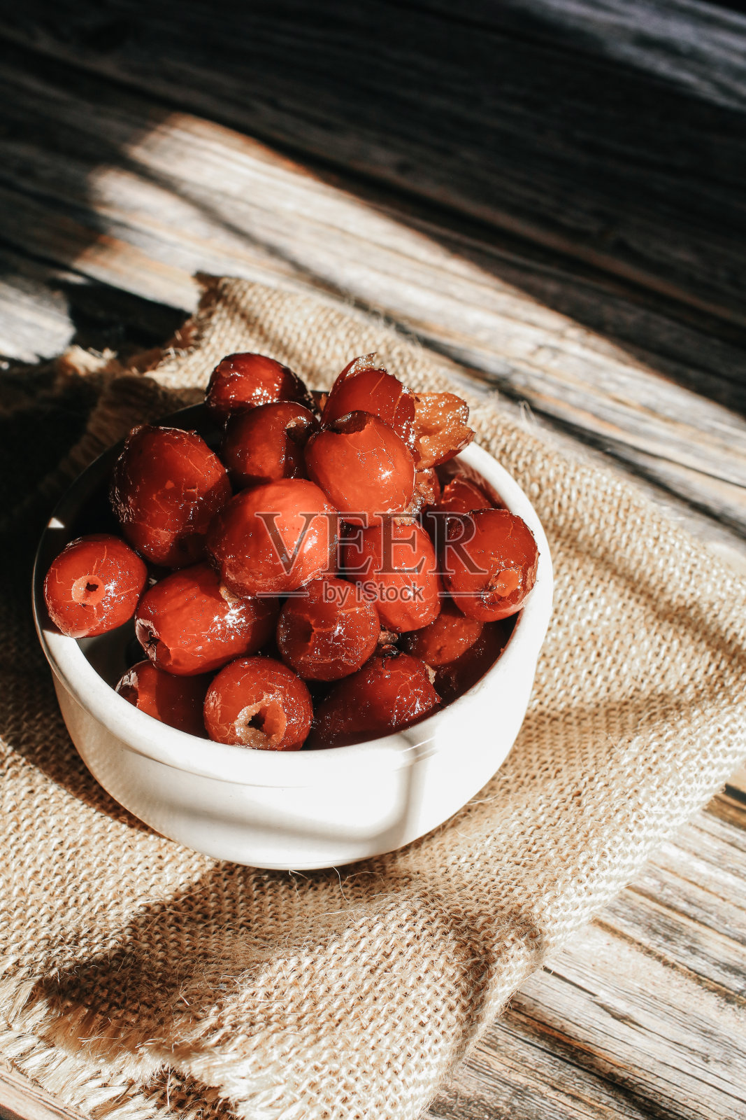 白碗里的红枣或红枣，阳光下靠窗。照片摄影图片