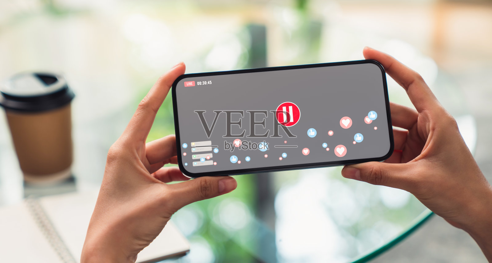 手持智能手机，在家用智能手机观看视频直播。照片摄影图片