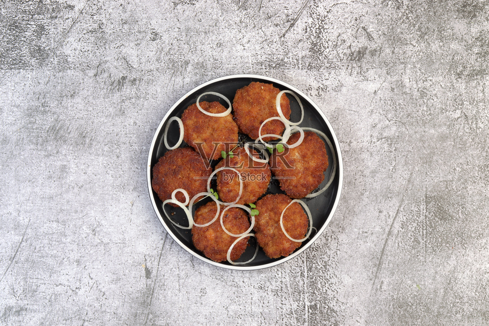 传统的自制肉饼或肉排在一个圆形盘子上，背景为深灰色。俯视图，平躺照片摄影图片