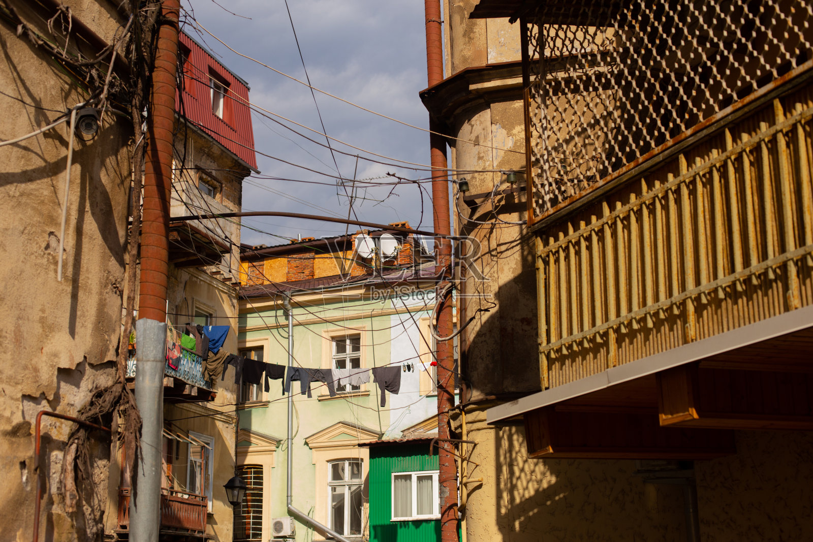 敖德萨，乌克兰- 04 24 21:旧建筑立面的一部分，有窗户和阳台。老城区典型的房子里有亚麻和晾衣绳。阳光明媚的春天的照片照片摄影图片