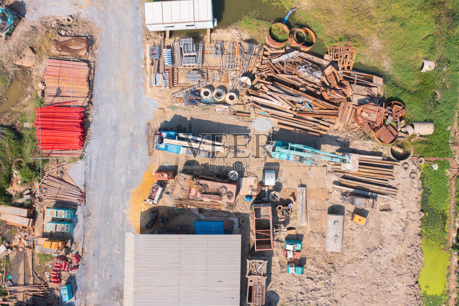 鸟瞰图，繁忙的工业施工现场工人与挖掘机在当地工厂工作。前视图。开发建设。照片摄影图片