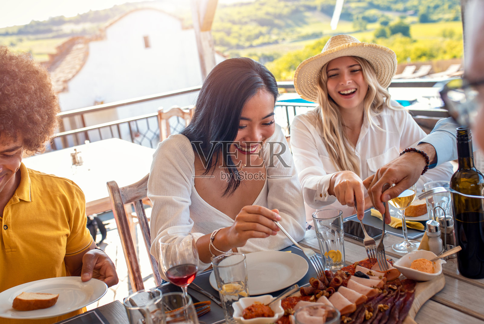 一群朋友聚在一起吃饭喝酒。照片摄影图片