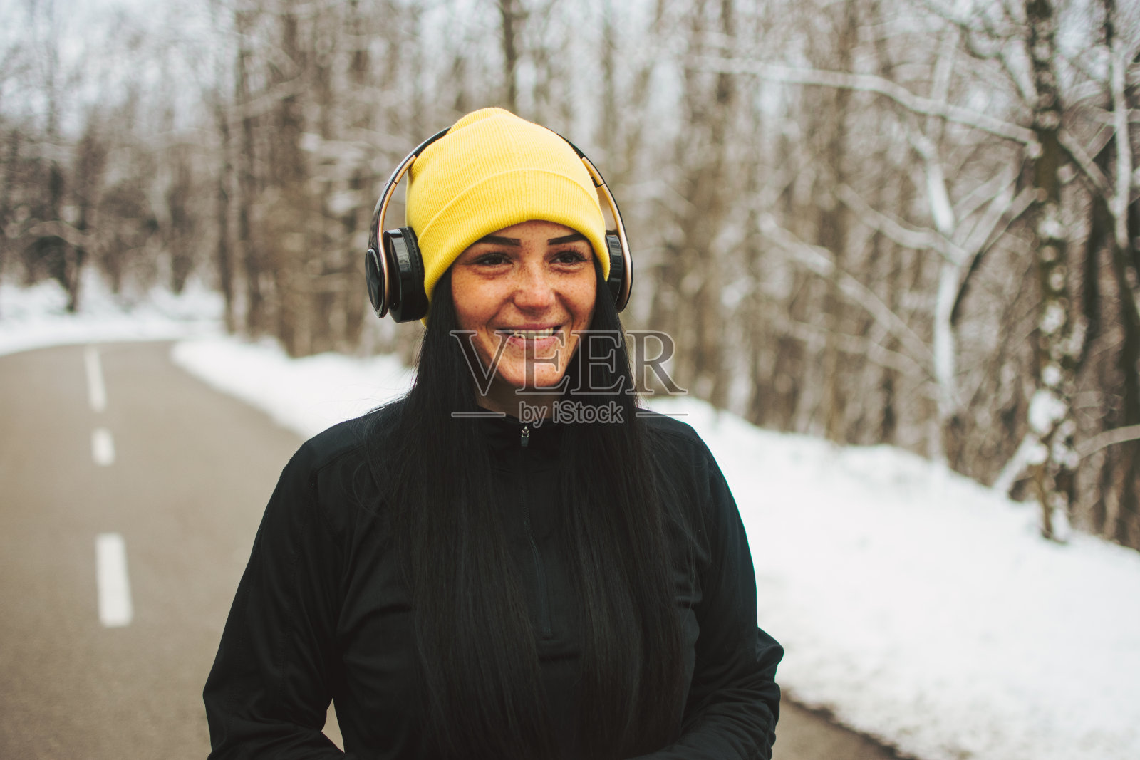 小女孩，戴着耳机听音乐。照片摄影图片