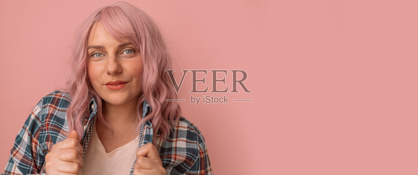 专注的年轻白人妇女看着在粉色粉彩背景与文本空间的相机照片摄影图片