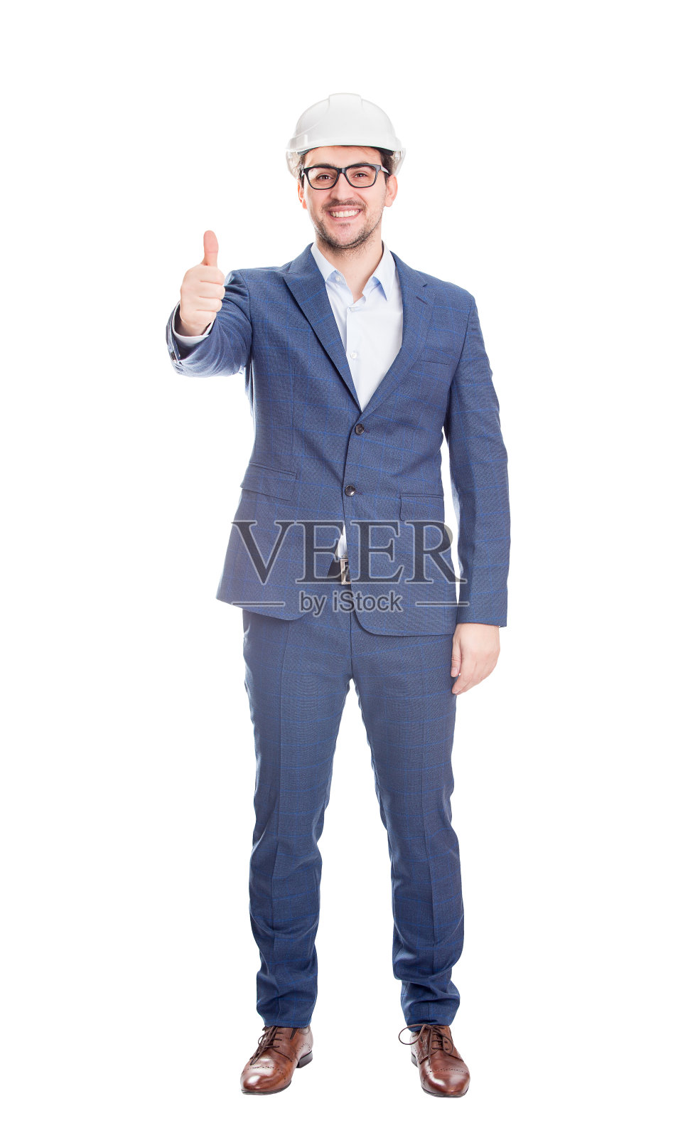快乐快乐的商人工程师的全长肖像，戴着防护头盔微笑显示拇指向上积极的姿态，看着孤立在白色背景的相机照片摄影图片