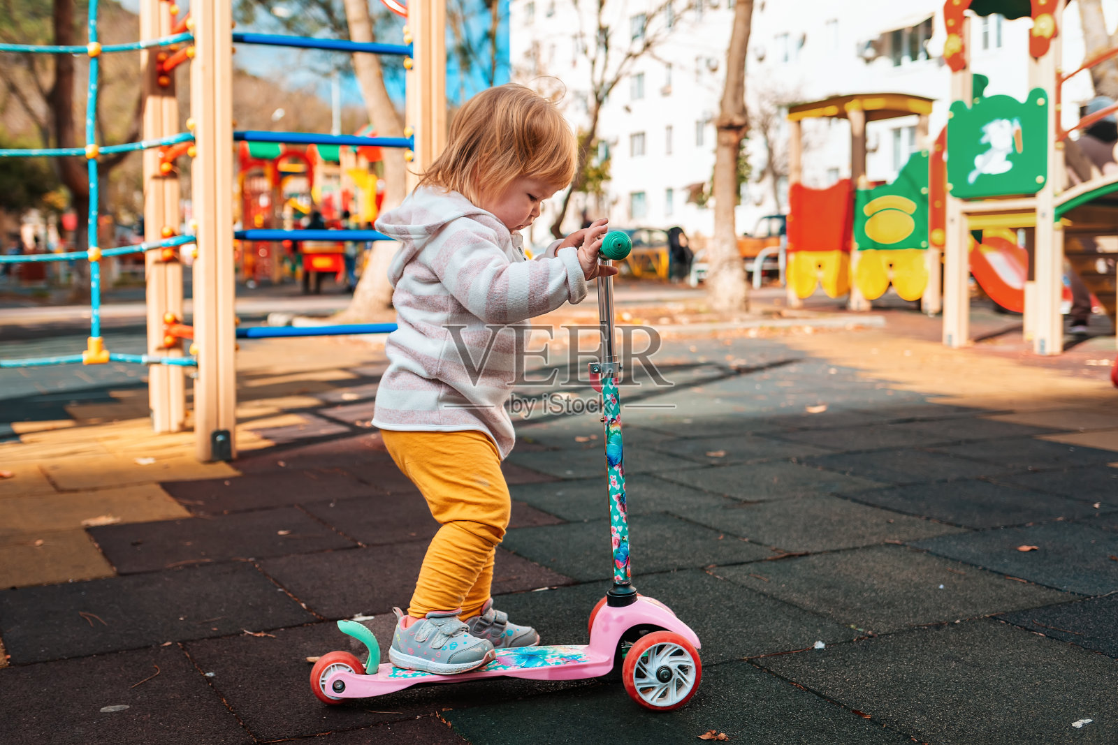 小女孩在操场上学习骑滑板车照片摄影图片