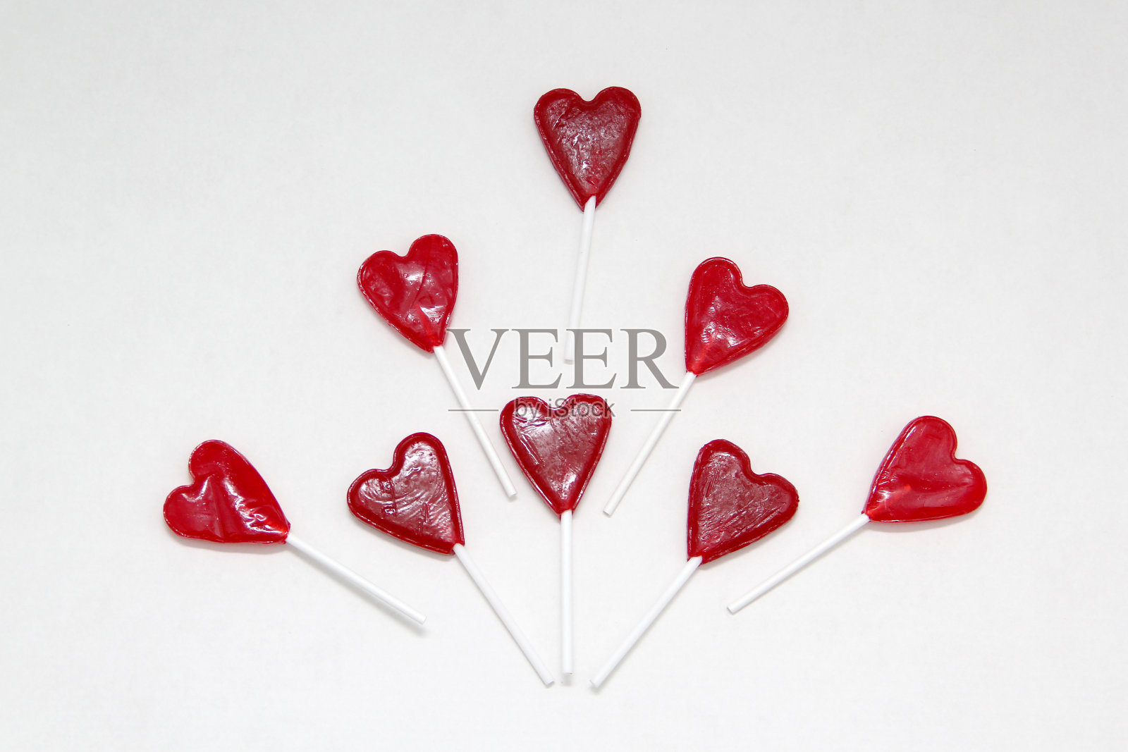 红心形状的糖果棒棒糖作为情人节的爱情和友谊的礼物作为贺卡上的白色背景照片摄影图片