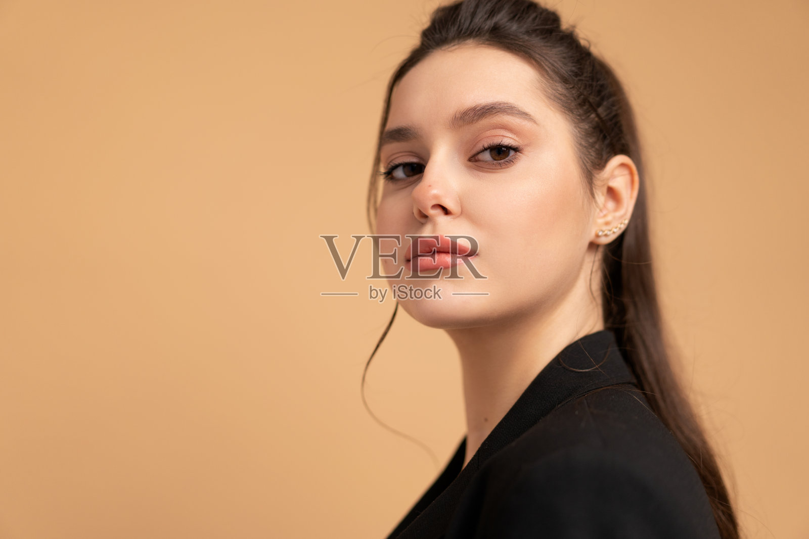 年轻的商业女性特写肖像穿着黑色夹克站在工作室孤立的颜色背景。照片摄影图片