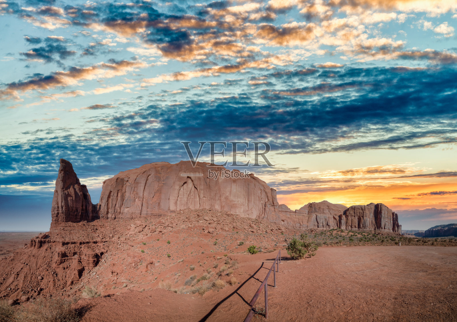 在美国亚利桑那州和犹他州之间的科罗拉多高原的一个地区，在纪念谷的日落天空中有黄色的条纹照片摄影图片