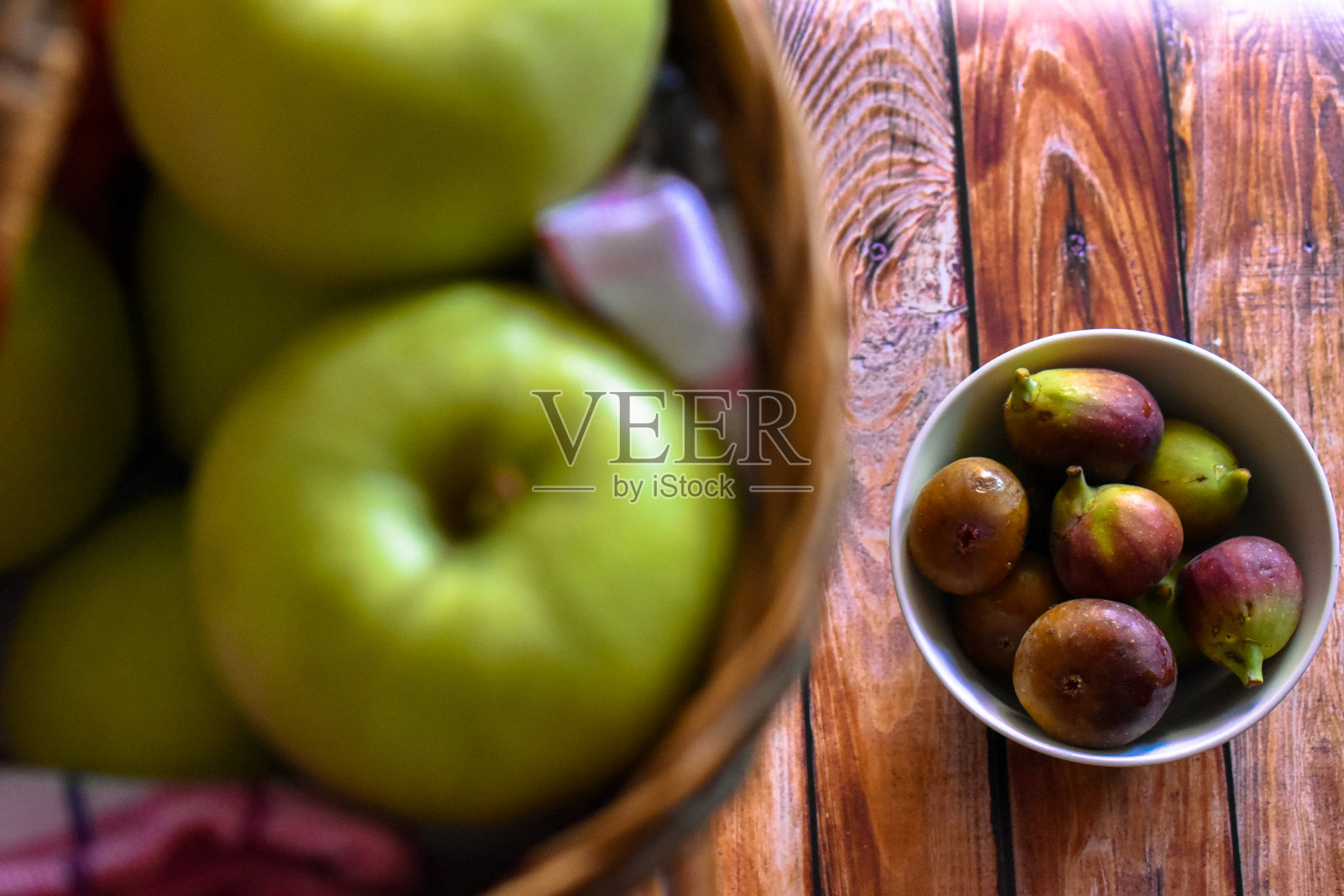 碗里有无花果，篮子里有青苹果照片摄影图片