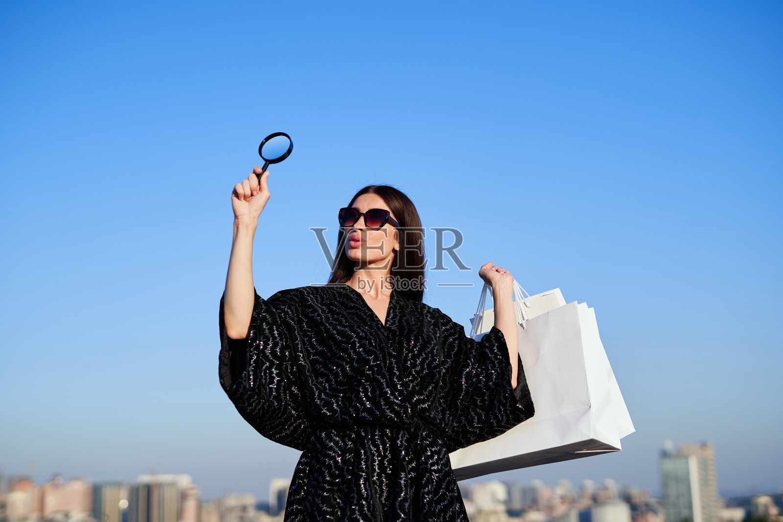 带着放大镜和购物袋的时尚女孩照片摄影图片