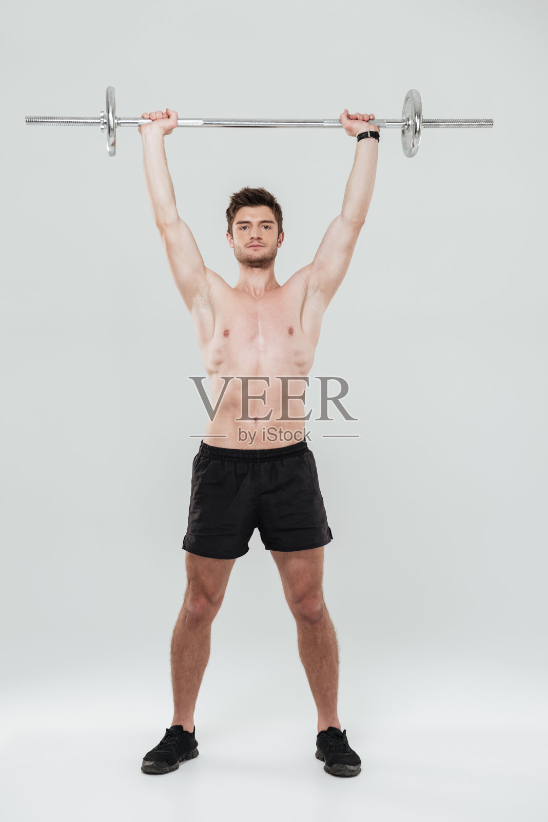 年轻健康男子运动员用杠铃锻炼身体照片摄影图片
