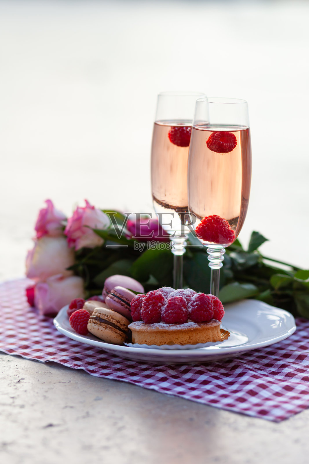 巴黎情人节浪漫求婚：粉红玫瑰花束、葡萄酒、马卡龙和蛋糕，埃菲尔铁塔背景照片摄影图片