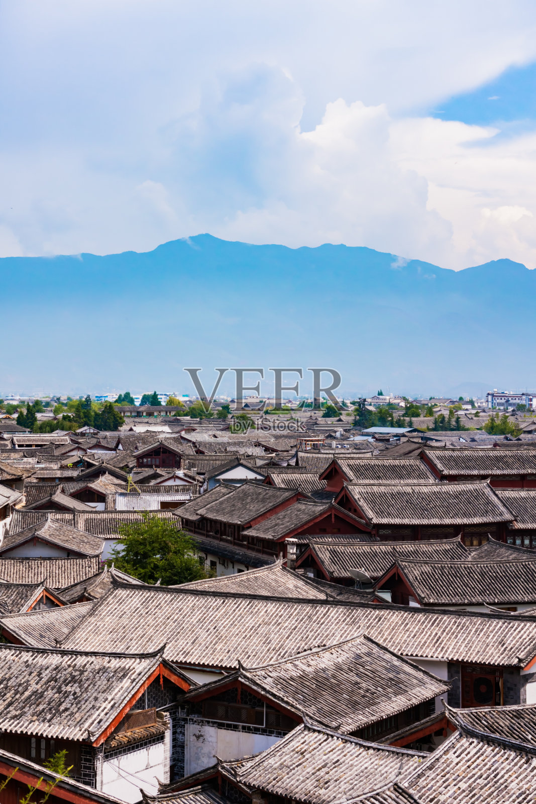 中国云南丽江古镇的建筑群，远处的群山和白云照片摄影图片