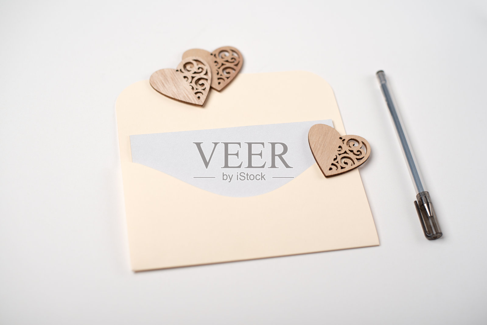 浅色(白色)背景上的一个信封和木制的心。照片摄影图片