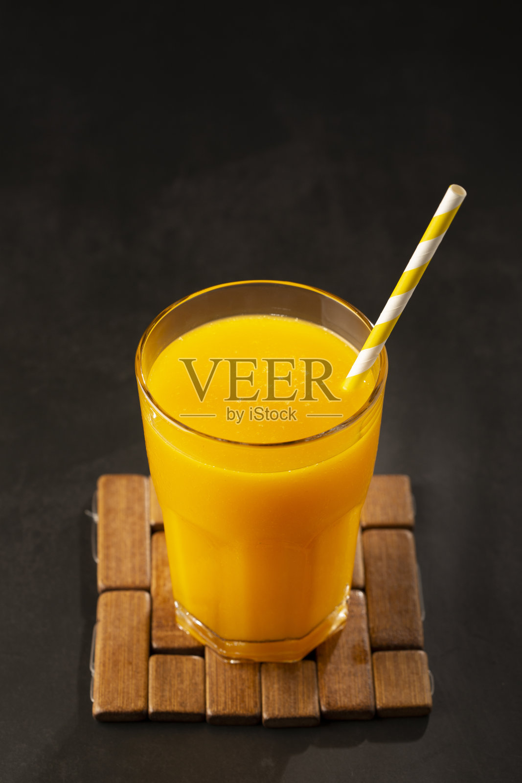 桌上的玻璃杯里有芒果汁。芒果冰沙。照片摄影图片