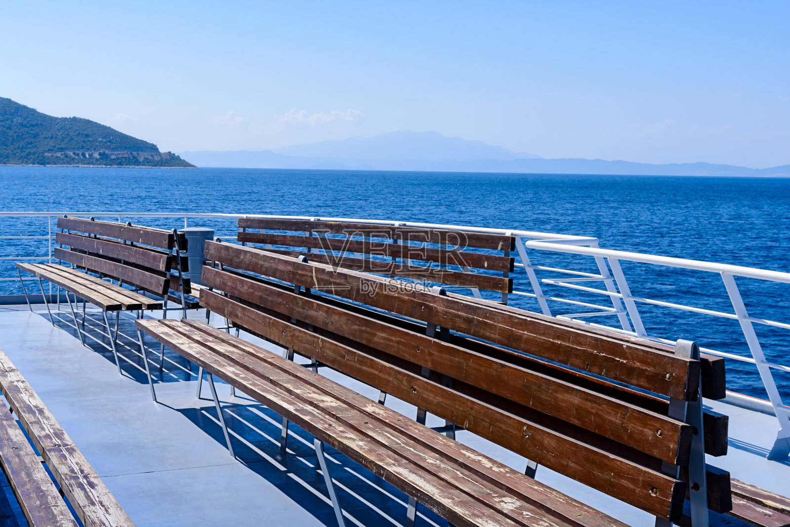 希腊，渡船甲板上的空木椅照片摄影图片