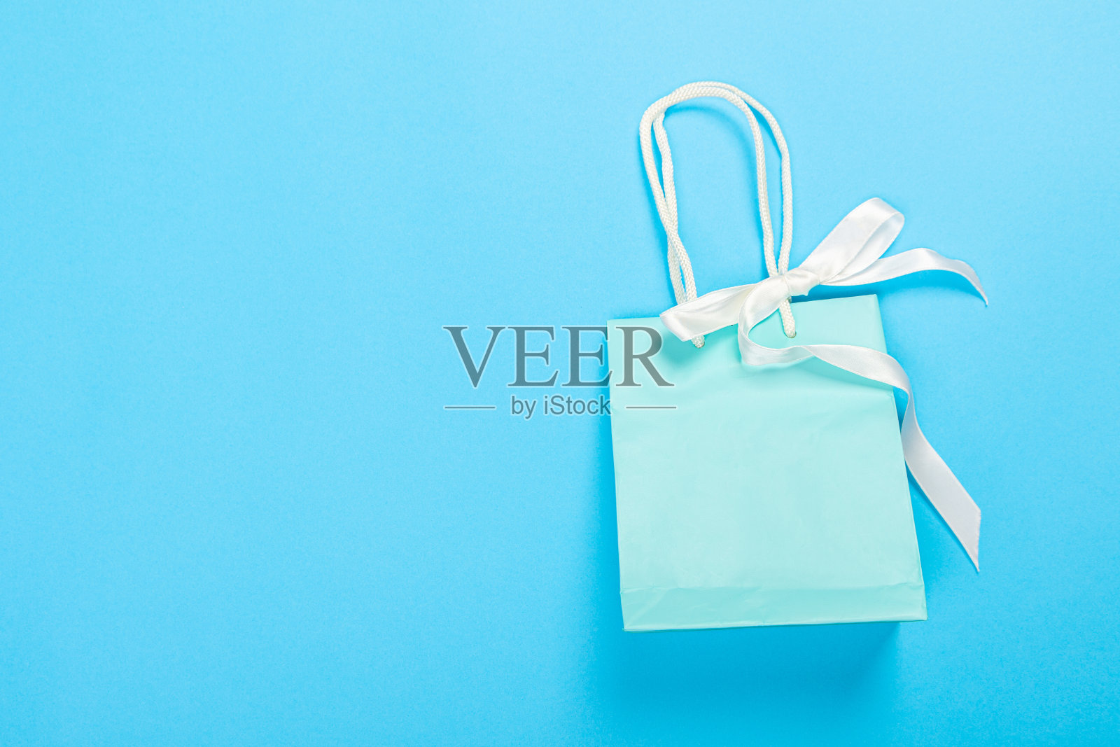 环保可回收纸礼品袋与处理蓝色背景照片摄影图片