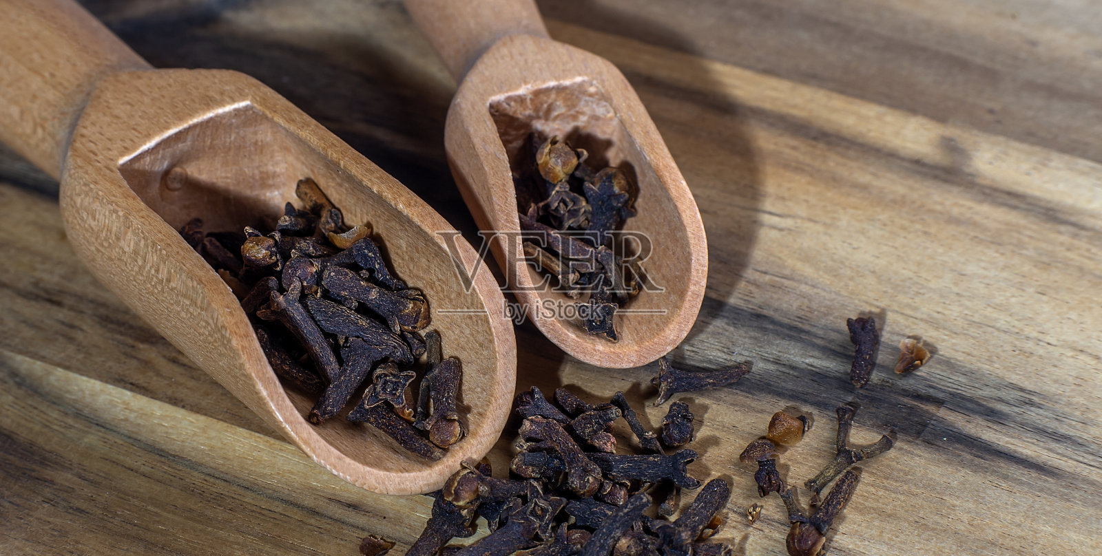 丁香放在木制背景的勺子上照片摄影图片