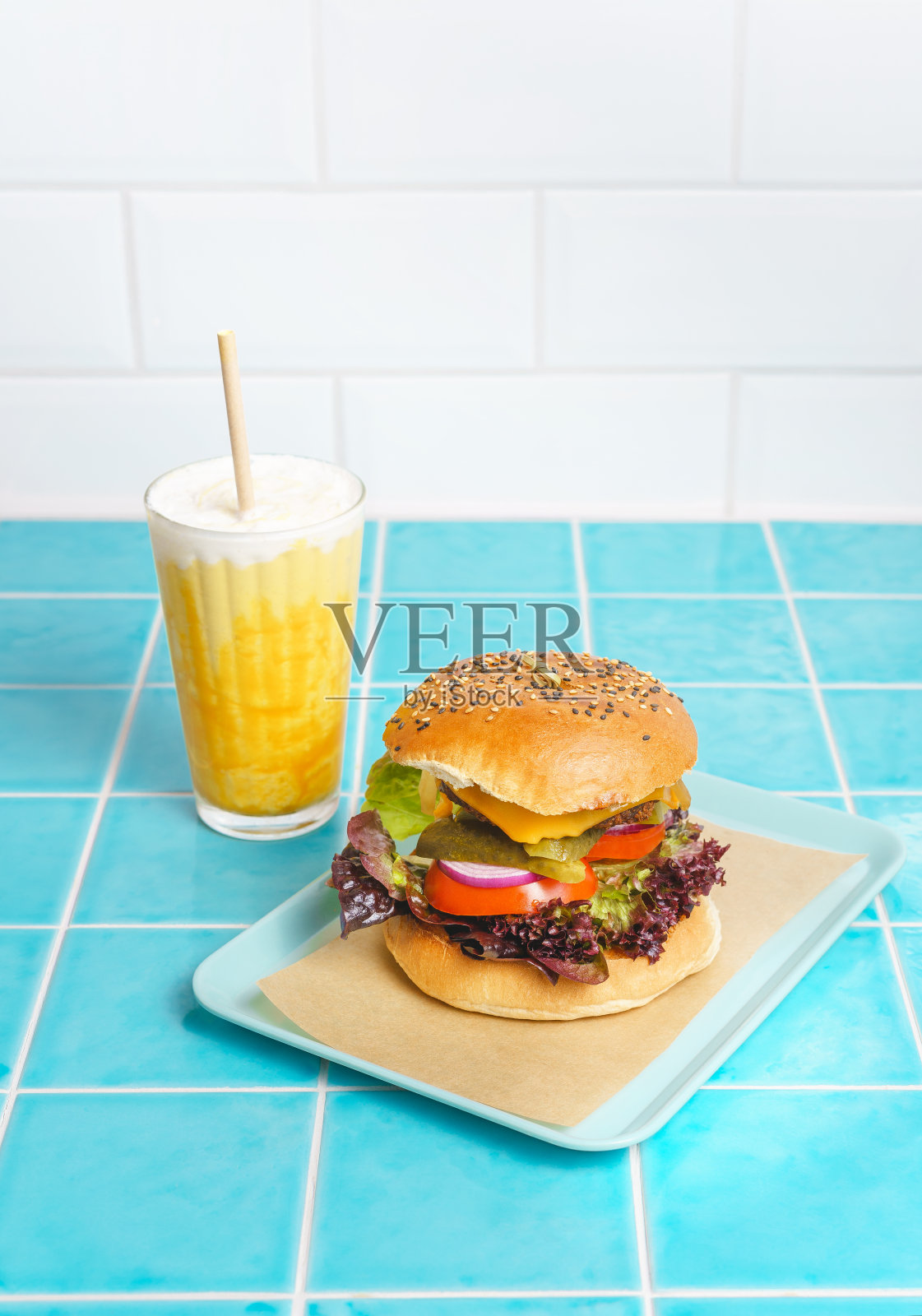 芒果冰沙和植物芝士汉堡在一个现代的咖啡馆照片摄影图片