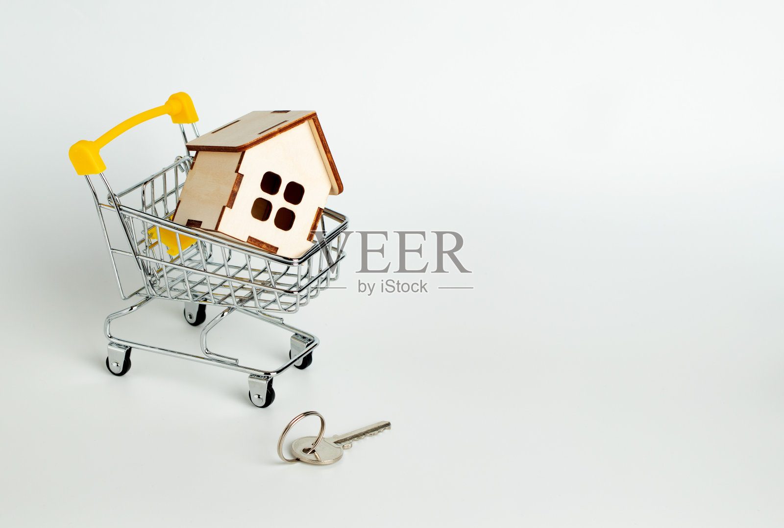 超市手推车上的木屋，钥匙。房屋买卖。抵押贷款和贷款照片摄影图片