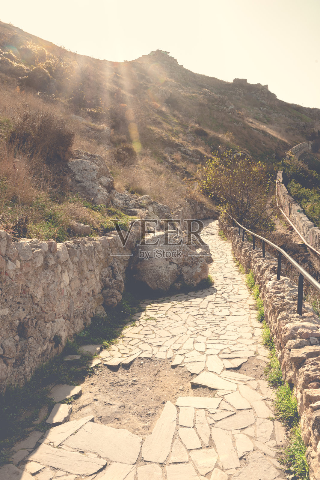 人行道上的山坡上有一块巨石在走照片摄影图片